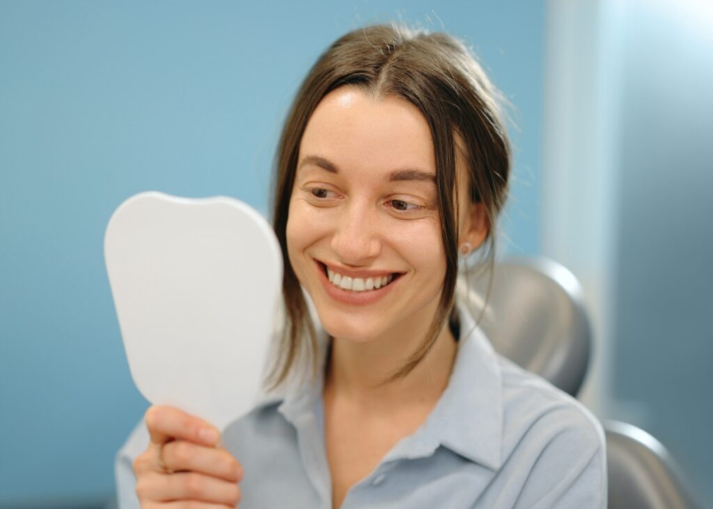 Patient smiling after receiving dental implants at Palm Beach Dental Specialists 