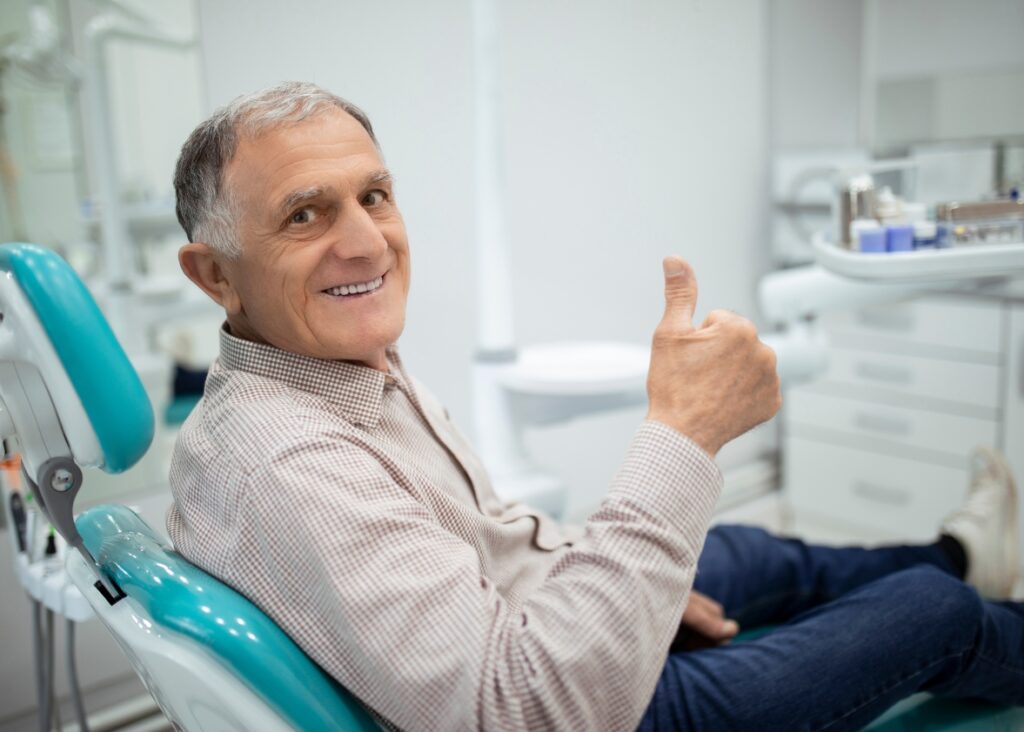 Satisfied patient showcasing radiant smile after treatment from dentist in Palm Beach