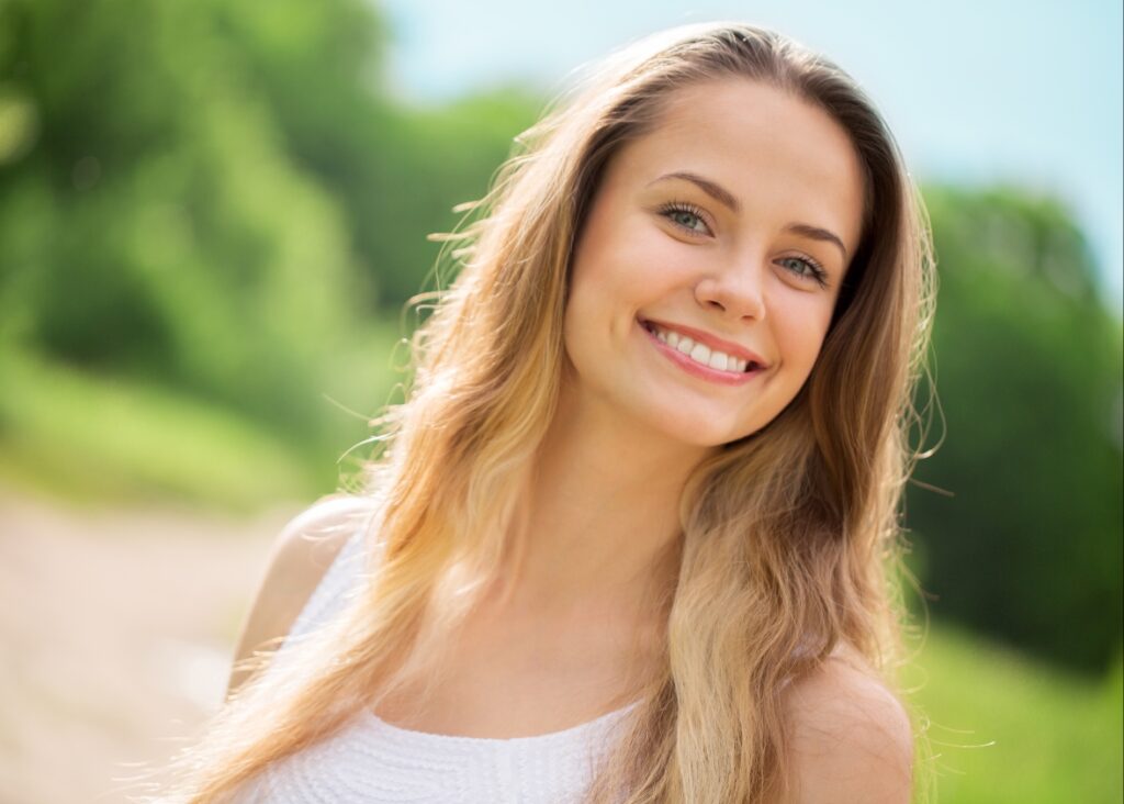 "A radiant woman showcasing her meticulously crafted smile by Palm Beach Dentistry.